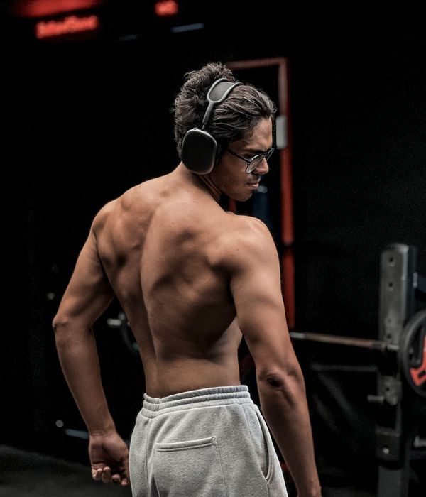 Man performing a powerful strength exercise in a modern, dark gym.
